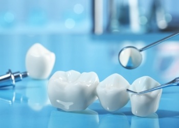 Dental bridge on desk next to dental mirrors