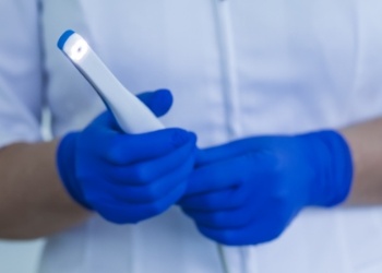 Dental team member holding a thin white intraoral camera