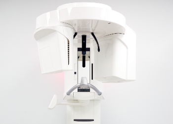 C T cone beam scanner standing against white wall