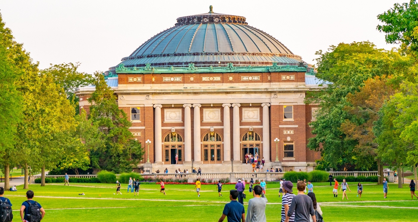 People walking across courtyard in front of university building