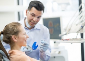 Dentist showing Invisalign to a patient in the dental chair