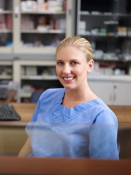 Smiling Gorham dental team member sitting at desk