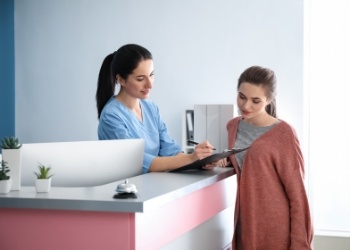 Dental team member showing a clipboard to a patient